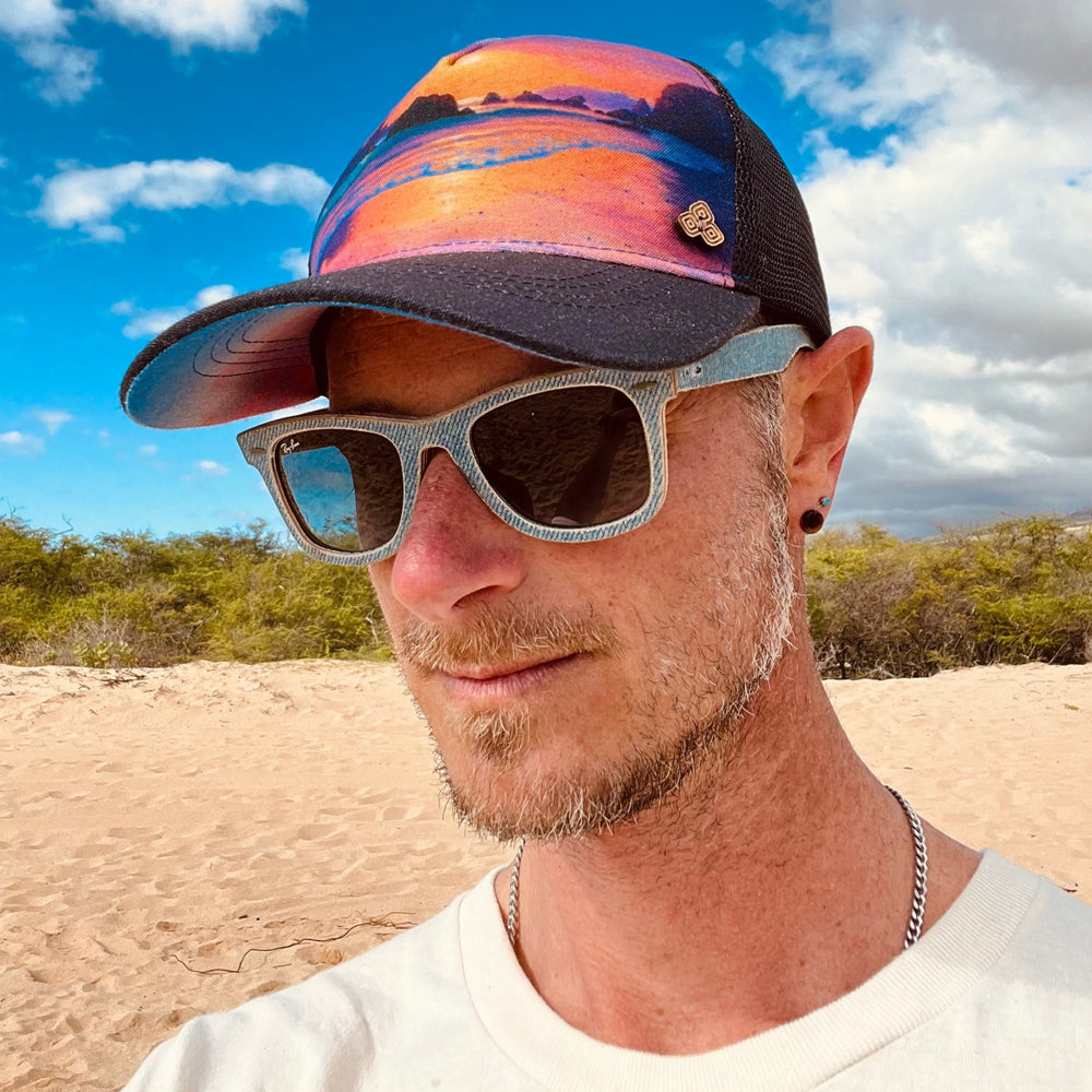 Male model profile styling the Horizon Trinidad Trucker Hat, featuring bold artwork, mesh back, and casual outdoor look.