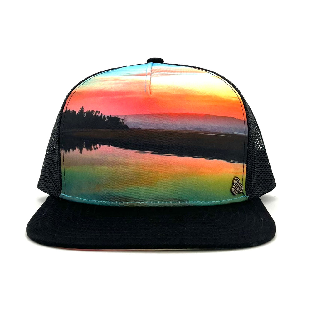 Front view of the Horizon Sunset Trucker Hat, featuring a Humboldt Bay sunset print, breathable mesh back, and adjustable snap closure.