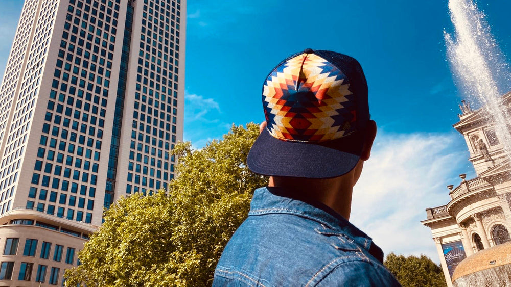 Male model styling the Santa Fe Trucker Hat, showcasing adjustable mesh back, southwestern graphic, and comfortable fit.