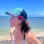 Female model wearing the Waves Trucker Hat, highlighting eco-friendly beach style and breathable design.