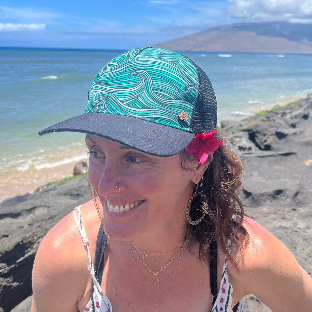 Female model wearing the Waves Trucker Hat, highlighting eco-friendly beach style and breathable design.