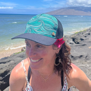 Female model wearing the Waves Trucker Hat, highlighting eco-friendly beach style and breathable design.